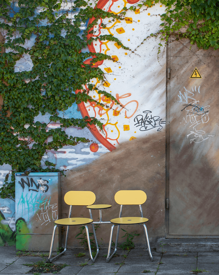 To gule Plateau City Chairs op ad en graffiti væg